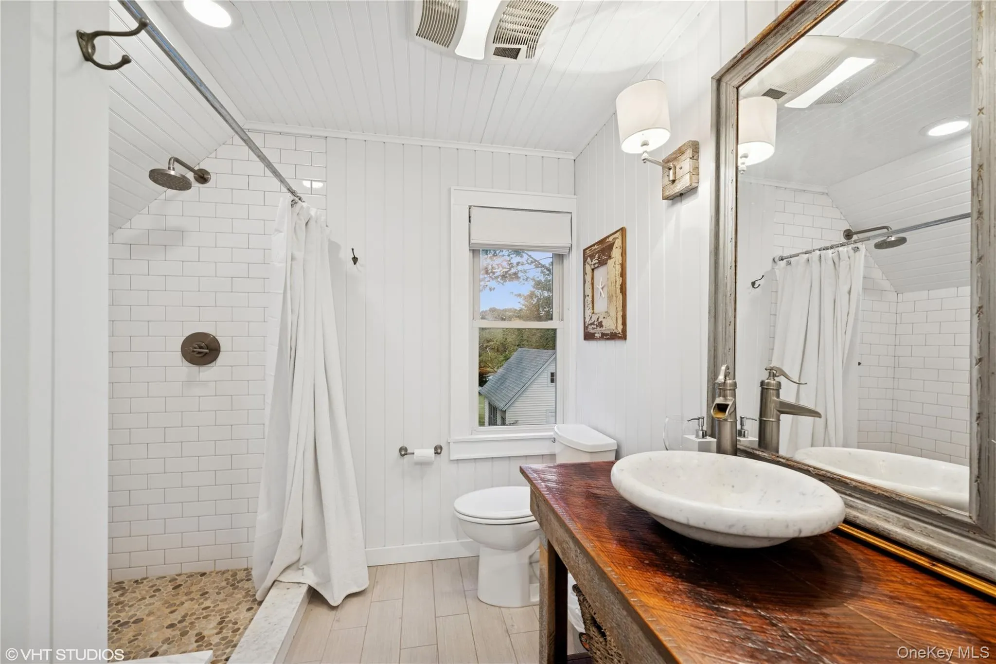 Bathroom featuring toilet, a tile shower, and vanity Bathroom featuring toilet, a tile shower, and vanity