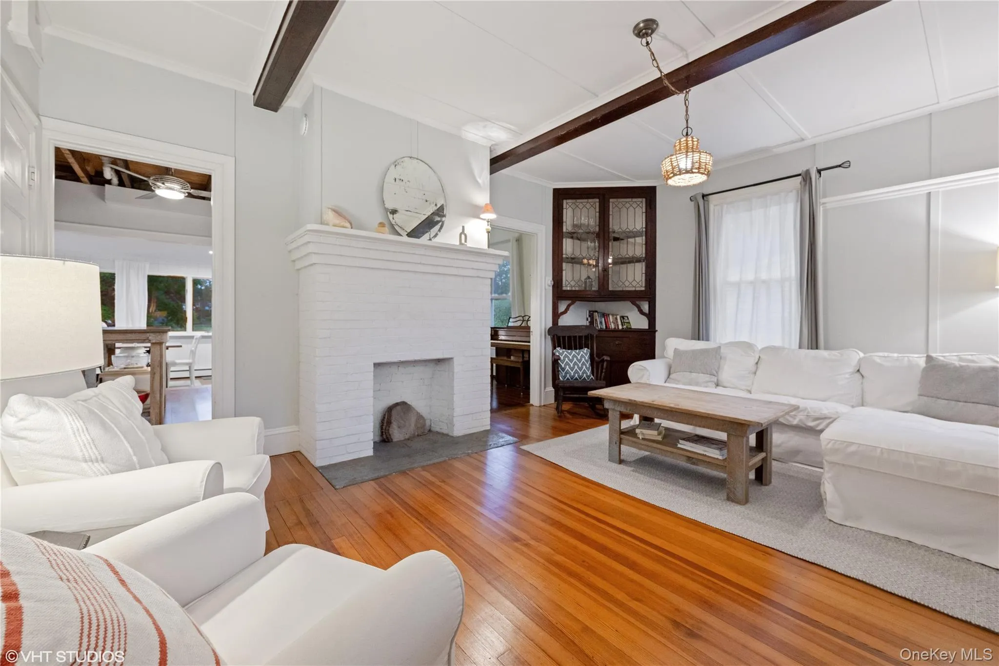 Living area with hardwood / wood-style floors, beam ceiling, and a fireplace Living area with hardwood / wood-style floors, beam ceiling, and a fireplace