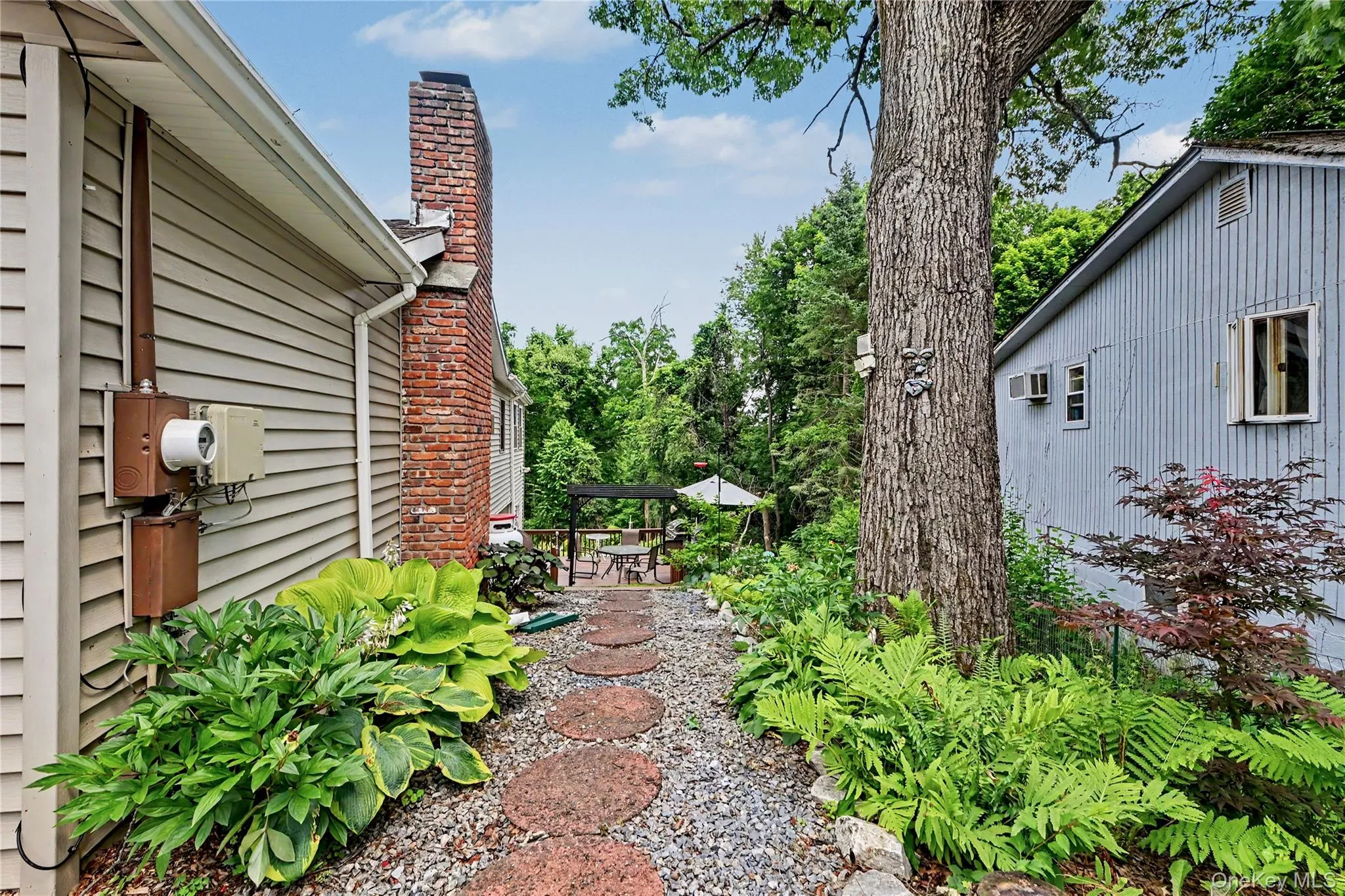 Side yard with stone path to deck. Side yard with stone path to deck.
