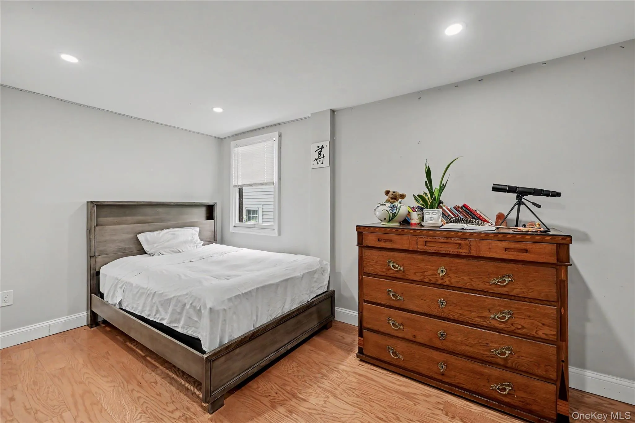 Bedroom with light-toned wood-finish flooring that complements the neutral wall color. Bedroom with light-toned wood-finish flooring that complements the neutral wall color.