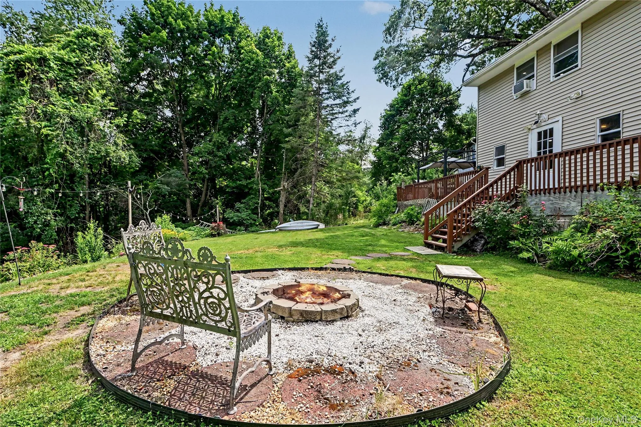 Fire pit sitting area with view of deck and backyard. Fire pit sitting area with view of deck and backyard.
