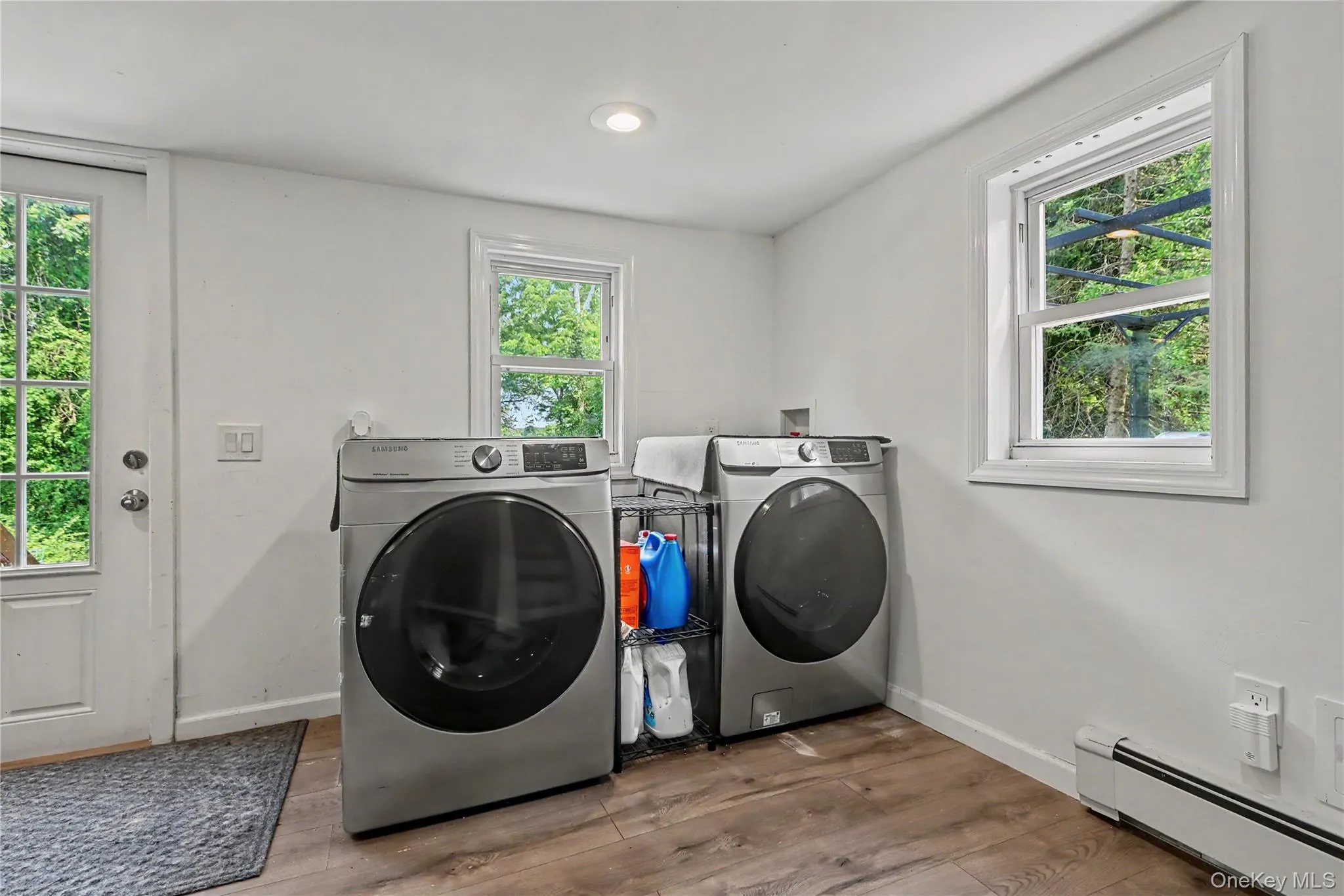 Dedicated laundry area featuring wood-finish tile flooring and recessed lighting. Dedicated laundry area featuring wood-finish tile flooring and recessed lighting.