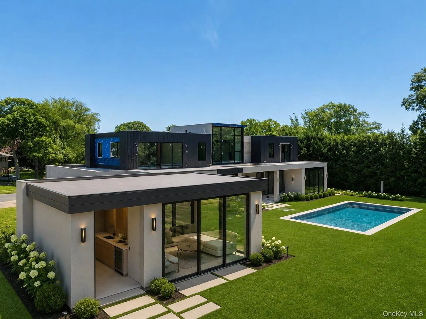Modern architectural design featuring expansive glass panels, a private swimming pool, and a manicured lawn Modern architectural design featuring expansive glass panels, a private swimming pool, and a manicured lawn