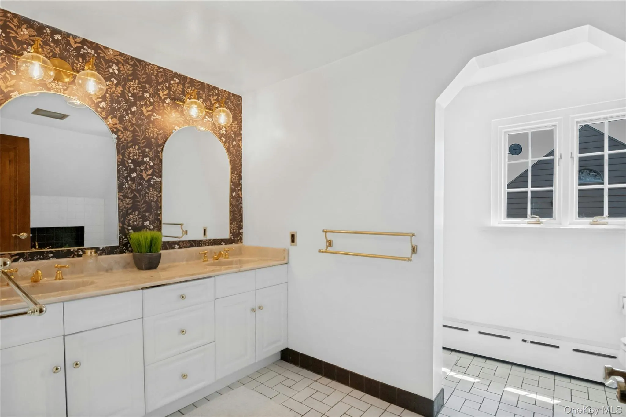 Dual vanity featuring white cabinetry, light-toned countertop, and gold-toned fixtures Dual vanity featuring white cabinetry, light-toned countertop, and gold-toned fixtures