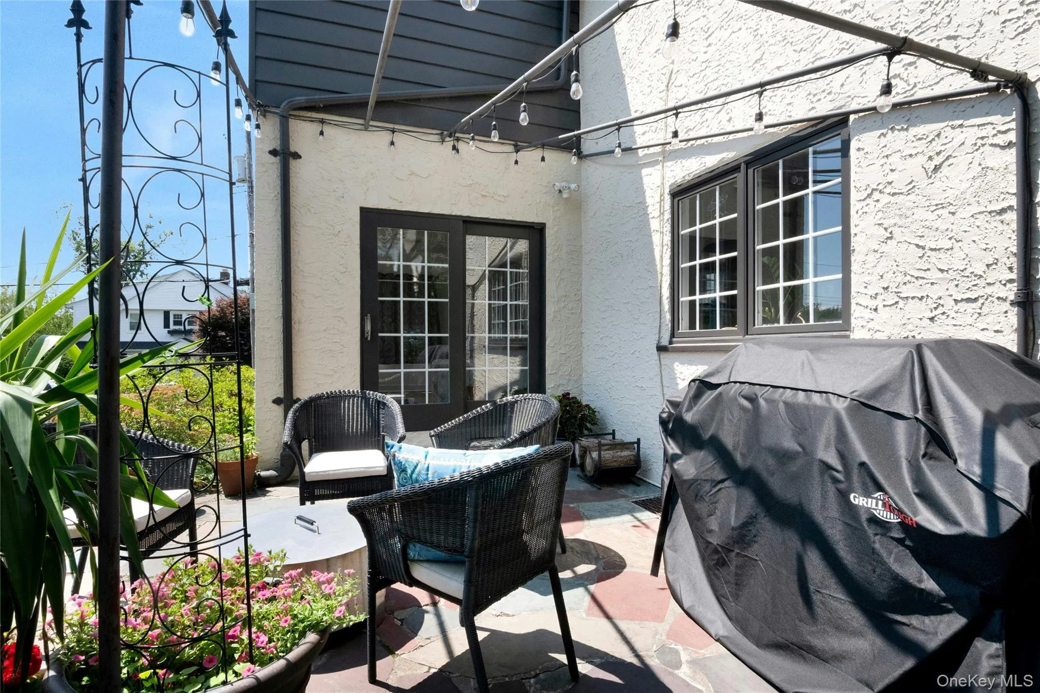 Outdoor patio featuring flagstone paving and a stucco exterior Outdoor patio featuring flagstone paving and a stucco exterior
