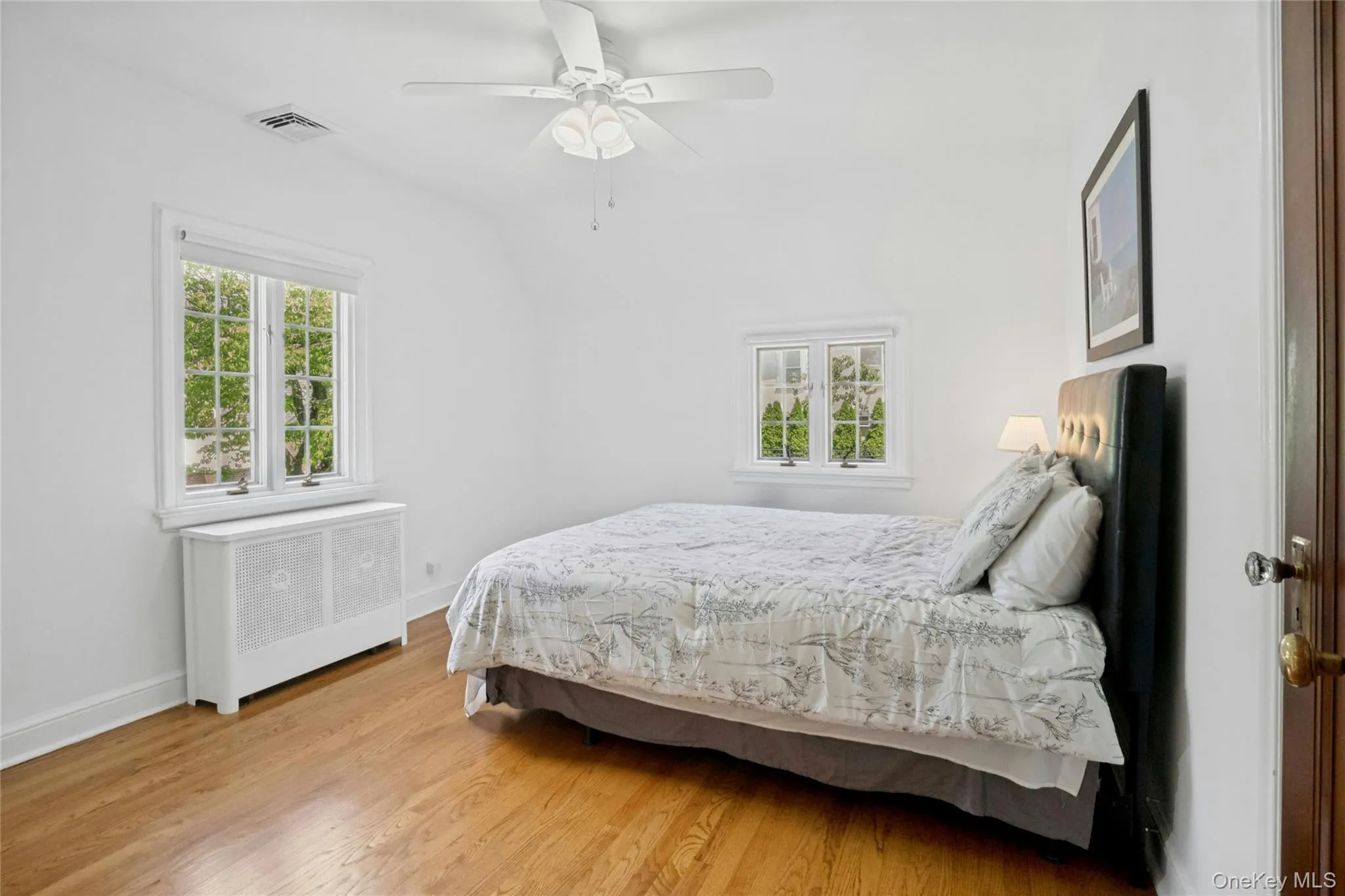 Hardwood flooring and white walls complement multiple windows Hardwood flooring and white walls complement multiple windows