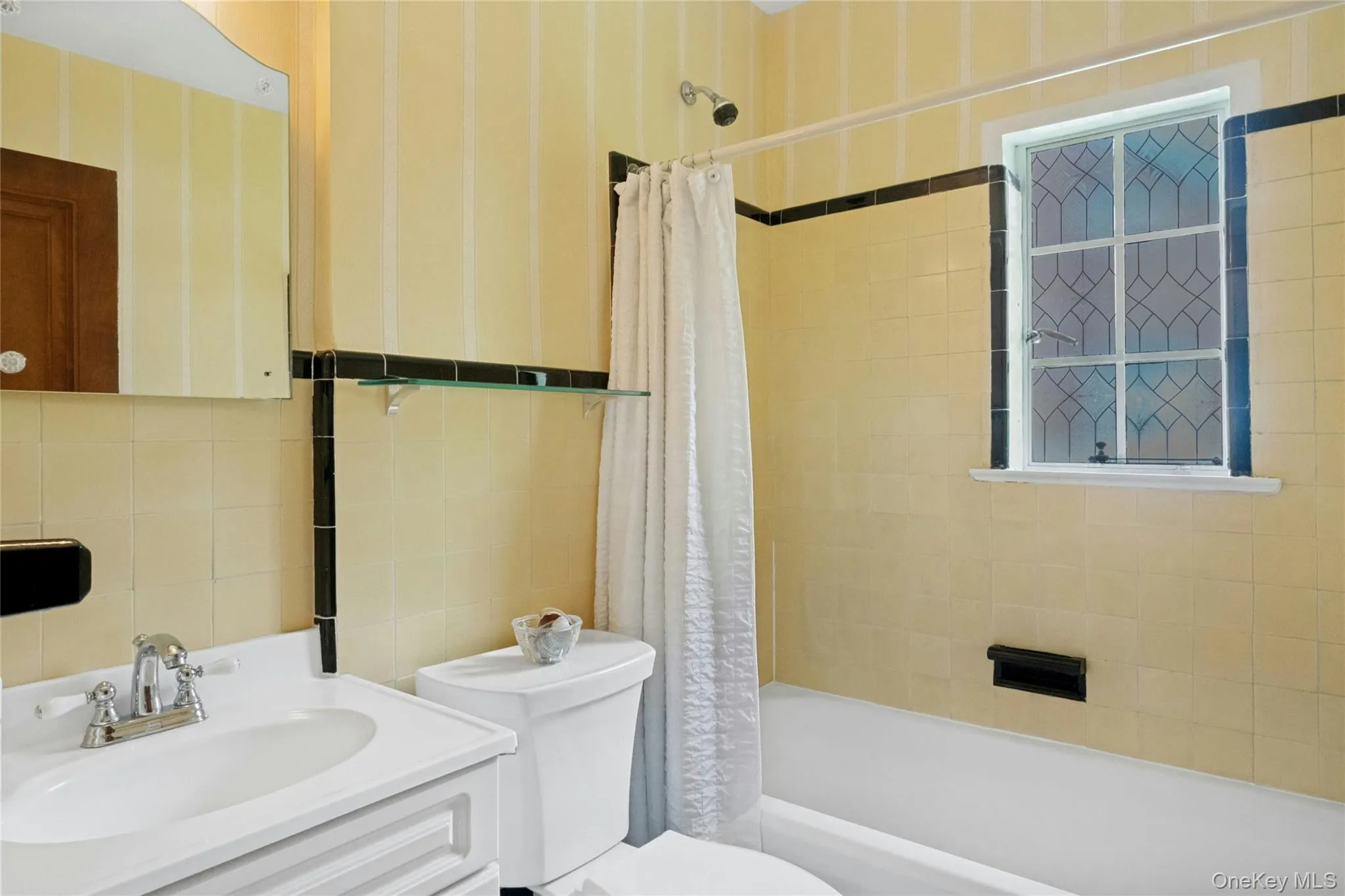 Bathroom featuring a white vanity with integrated sink, chrome faucet, and mirrored medicine cabinet Bathroom featuring a white vanity with integrated sink, chrome faucet, and mirrored medicine cabinet