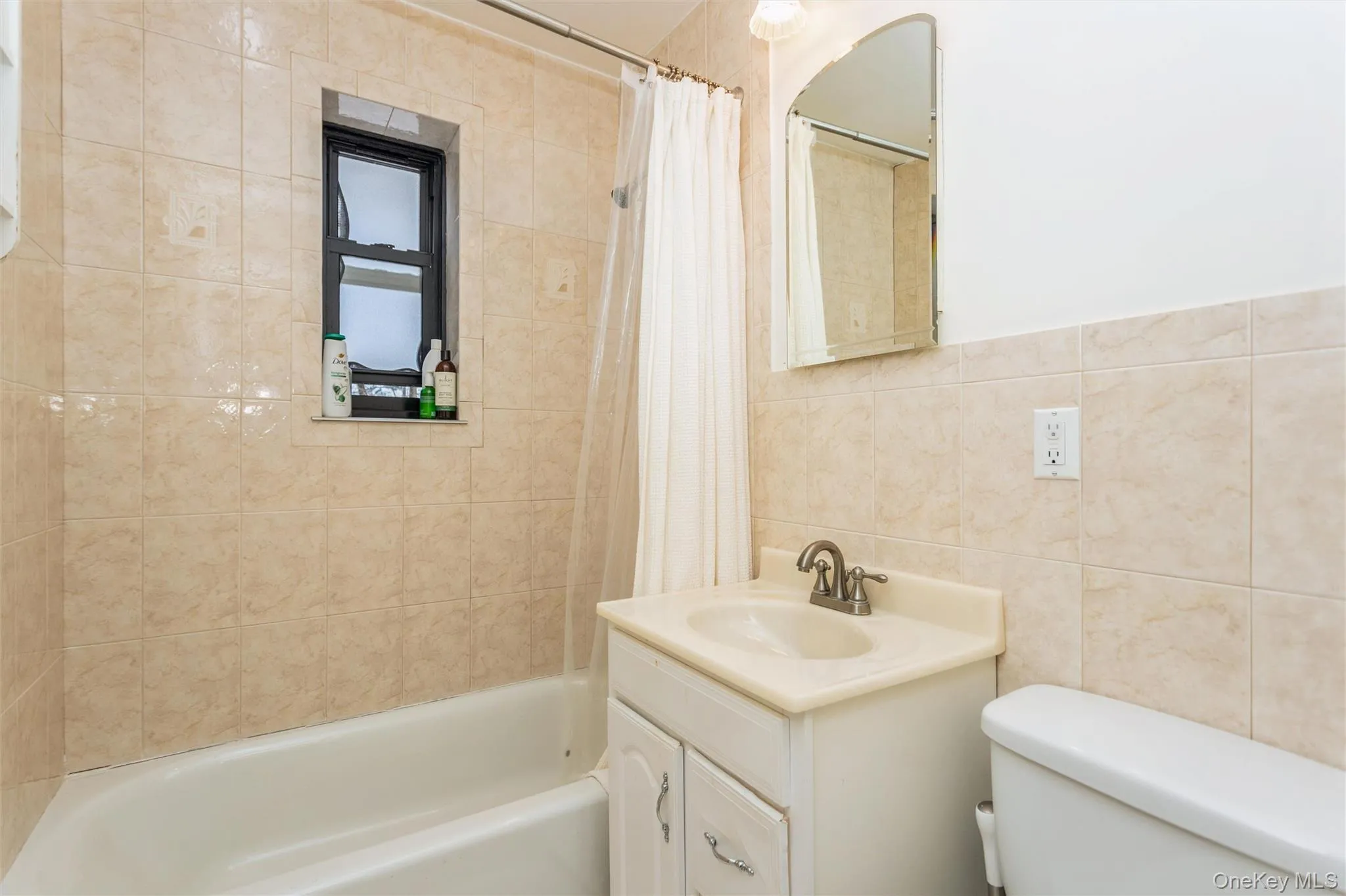Full bathroom featuring vanity, shower / bathtub combination with tile walls Full bathroom featuring vanity, shower / bathtub combination with tile walls
