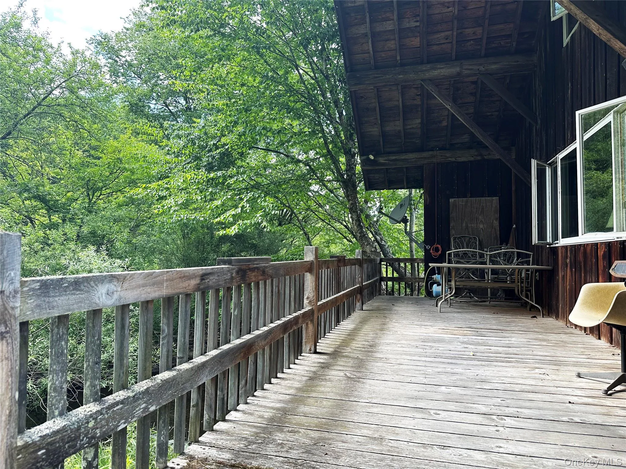 Covered deck positioned directly beside Trout Brook, creating a tranquil outdoor living and entertaining space immersed in nature. Covered deck positioned directly beside Trout Brook, creating a tranquil outdoor living and entertaining space immersed in nature.
