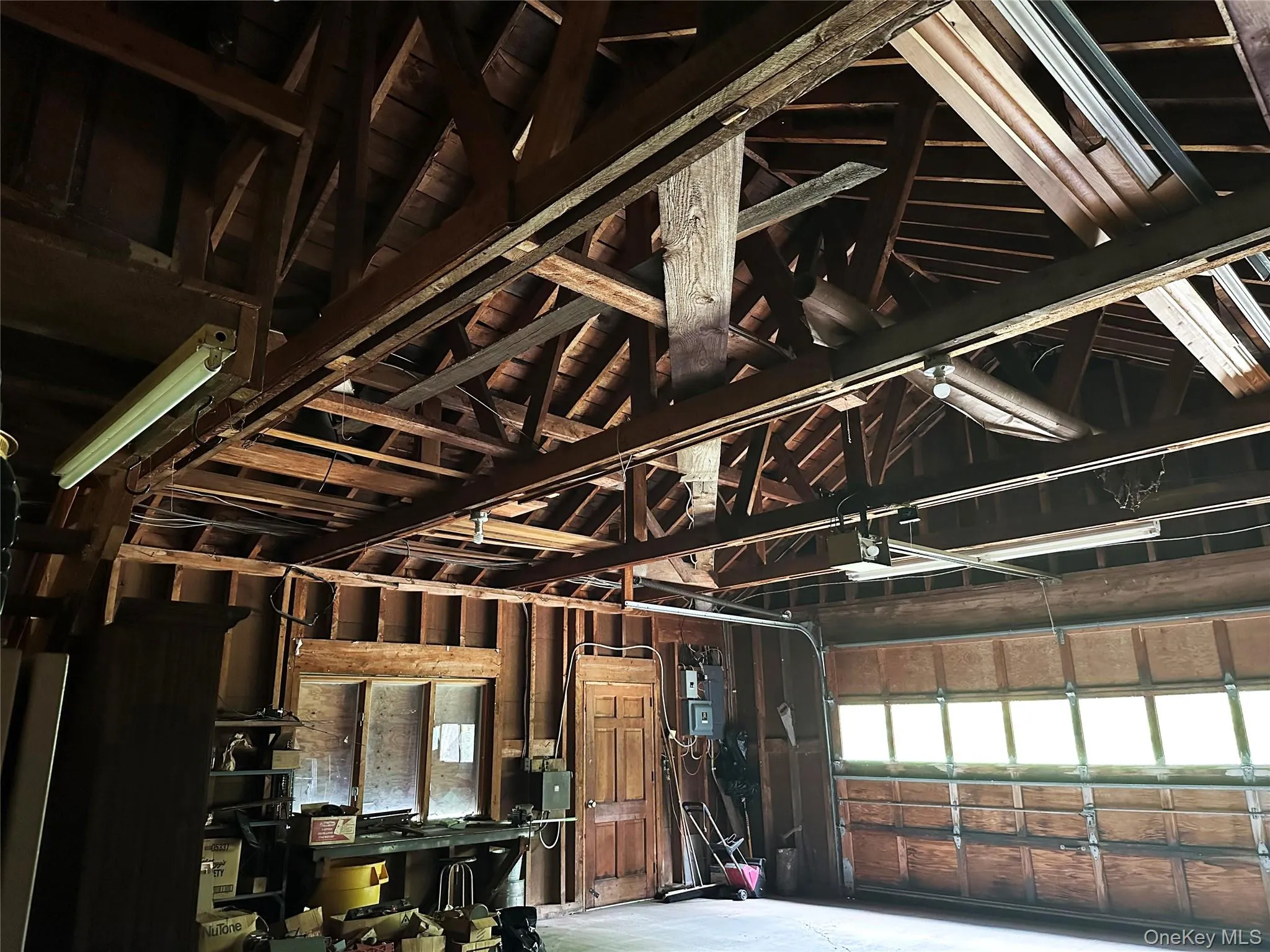 Oversized garage/workshop with soaring exposed trusses, substantial storage capacity, and space for equipment, hobbies, or recreational use. Oversized garage/workshop with soaring exposed trusses, substantial storage capacity, and space for equipment, hobbies, or recreational use.