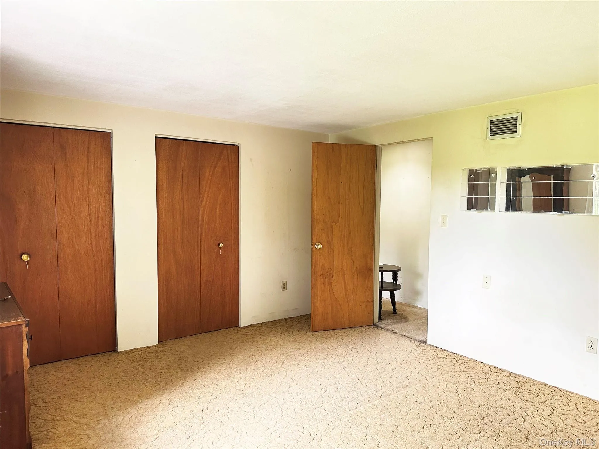 Spacious bedroom with dual closets, large windows, and peaceful views of the surrounding property. Spacious bedroom with dual closets, large windows, and peaceful views of the surrounding property.