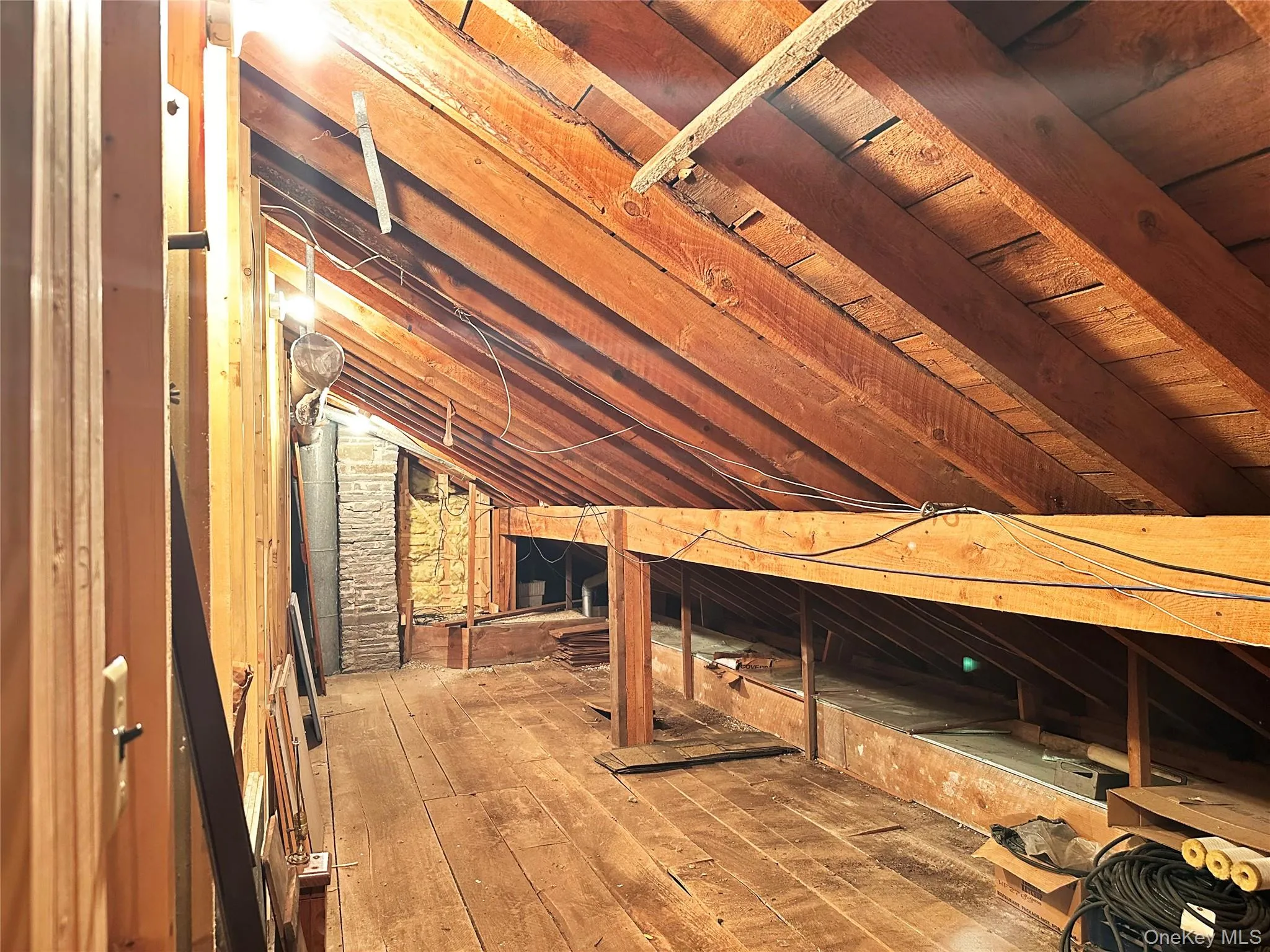 Walk-up attic storage area with exposed wood framing and substantial additional space for seasonal storage. Walk-up attic storage area with exposed wood framing and substantial additional space for seasonal storage.
