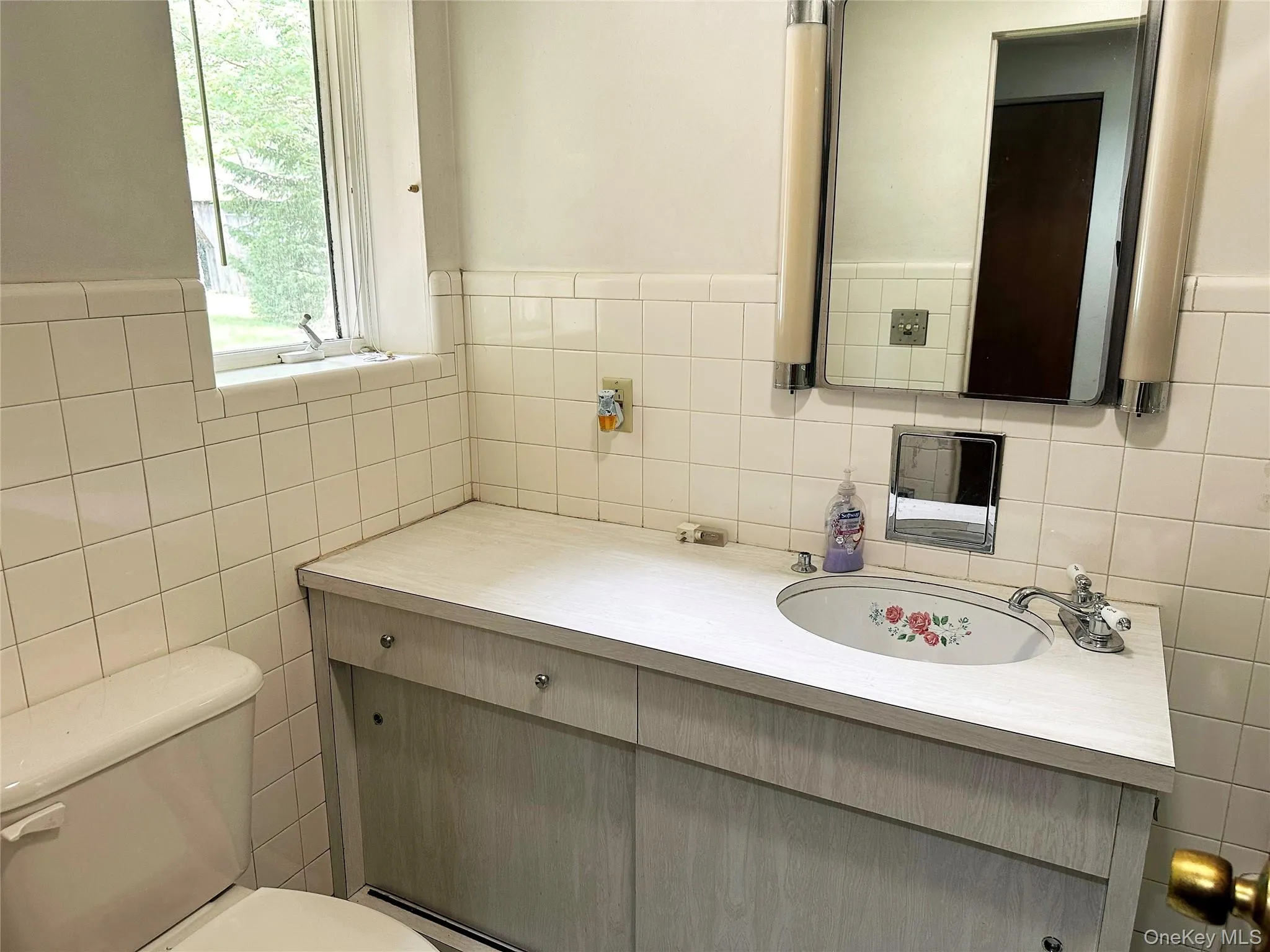 Vintage-style bathroom with updated vanity, original tilework, and natural light. Vintage-style bathroom with updated vanity, original tilework, and natural light.