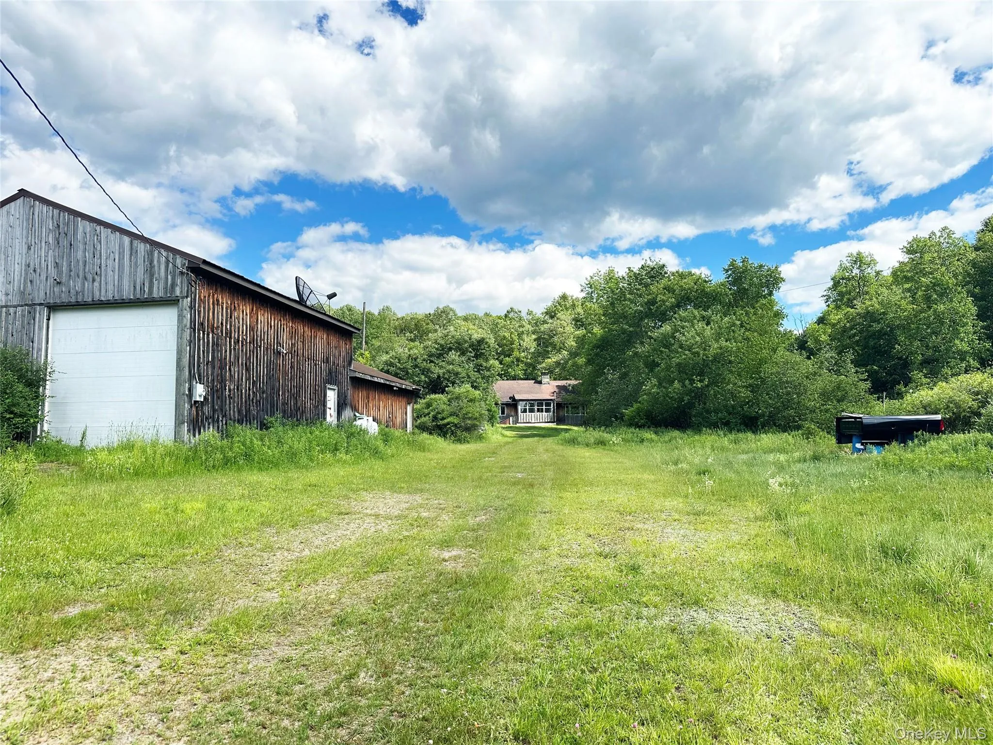 Long perspective showcasing the expansive grounds, detached garage, and secluded setting. Long perspective showcasing the expansive grounds, detached garage, and secluded setting.