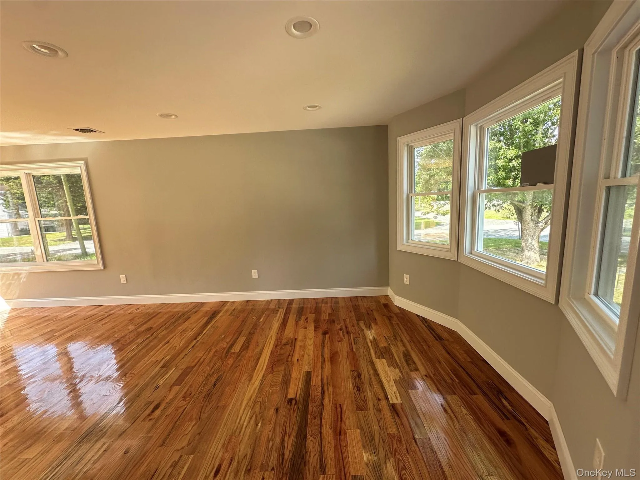 Hardwood flooring throughout featuring recessed lighting and multiple windows Hardwood flooring throughout featuring recessed lighting and multiple windows
