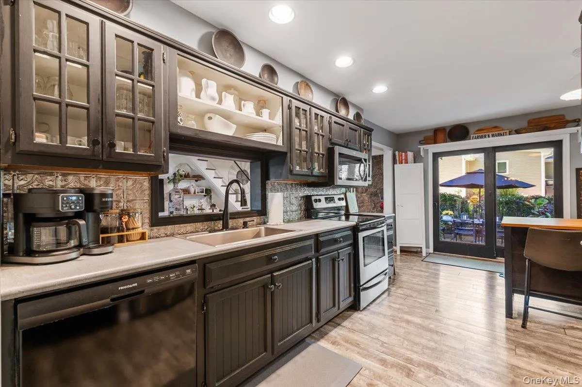 Kitchen featuring dark cabinetry, recessed lighting, and wood-finish flooring Kitchen featuring dark cabinetry, recessed lighting, and wood-finish flooring