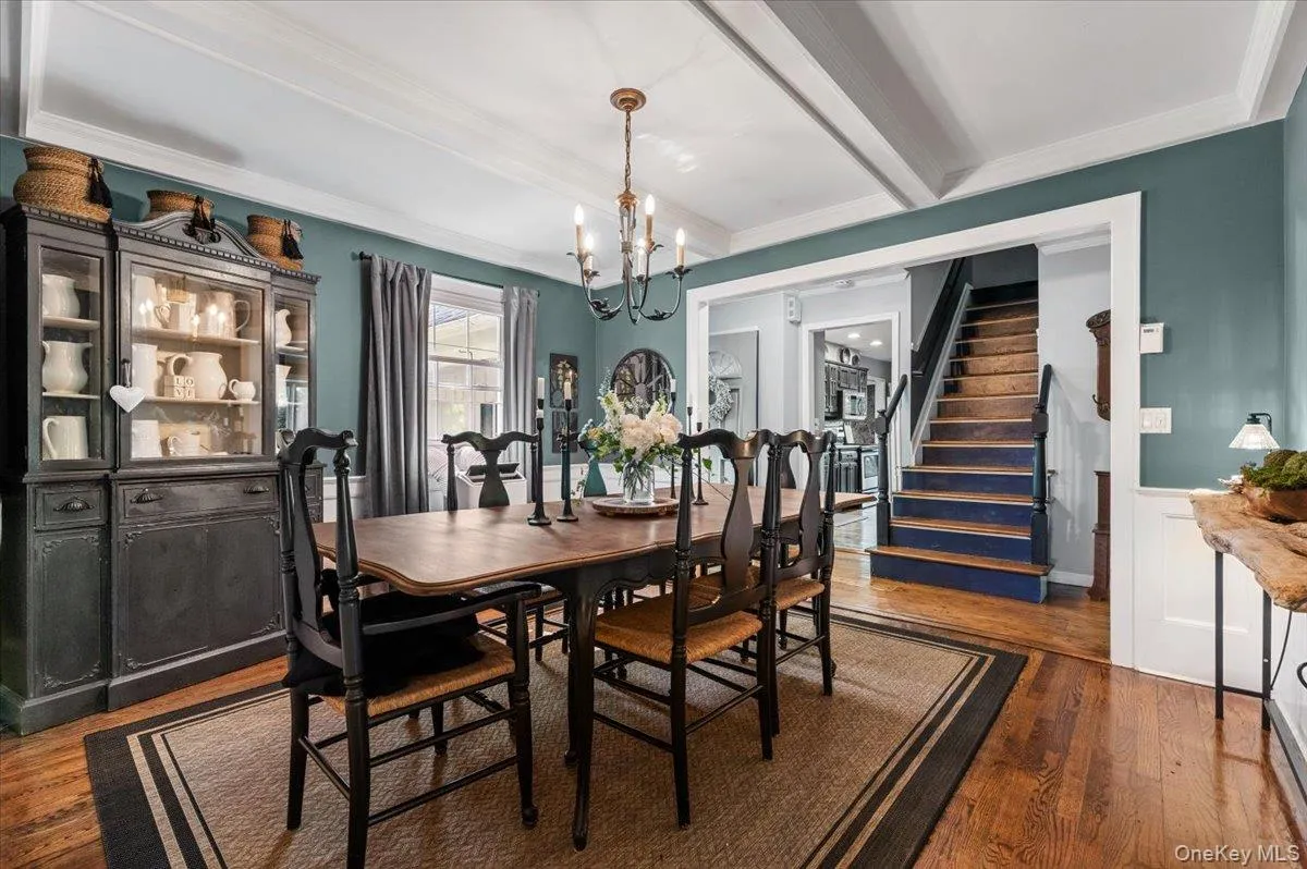 Dining area featuring wood-finish flooring, a coffered ceiling, and a chandelier Dining area featuring wood-finish flooring, a coffered ceiling, and a chandelier