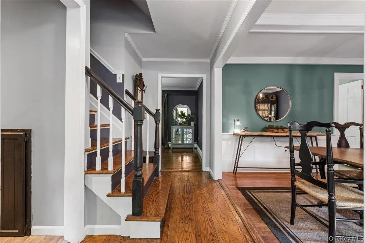 Entry foyer showcasing wood-finish flooring and a staircase with white risers and dark wood treads Entry foyer showcasing wood-finish flooring and a staircase with white risers and dark wood treads