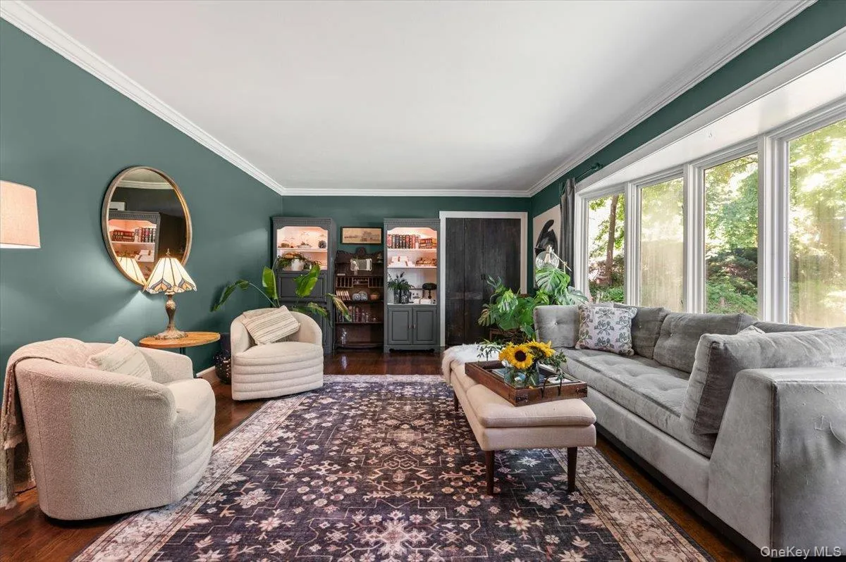 Living area featuring hardwood flooring and a large bay window Living area featuring hardwood flooring and a large bay window