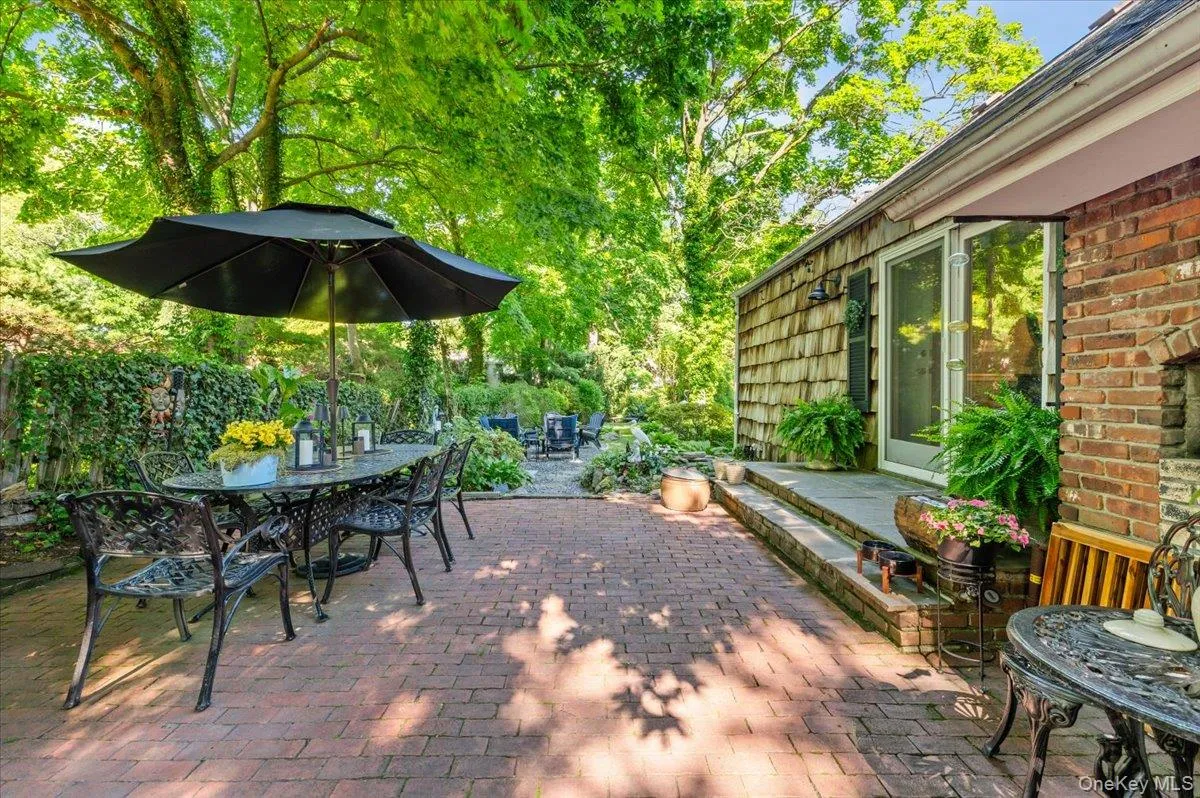 Brick paver patio with a cedar shake siding exterior, full-lite glass door, and an outdoor brick fireplace Brick paver patio with a cedar shake siding exterior, full-lite glass door, and an outdoor brick fireplace