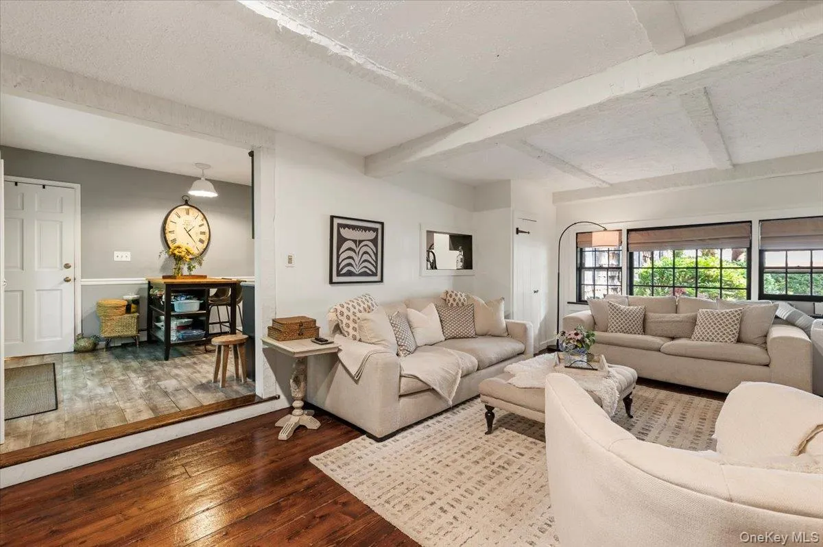 Living room with exposed ceiling beams and dark wood-finish flooring Living room with exposed ceiling beams and dark wood-finish flooring