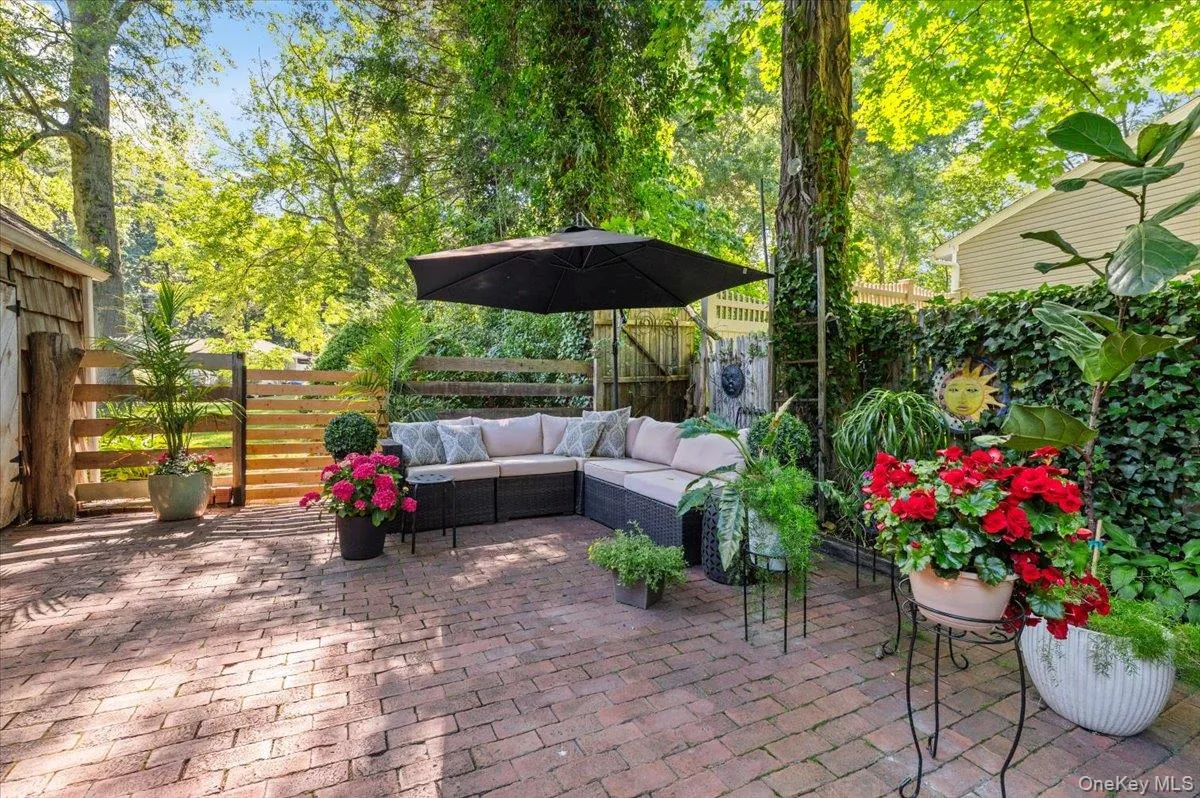 Brick paver patio featuring a slatted wood fence and a shingled shed Brick paver patio featuring a slatted wood fence and a shingled shed