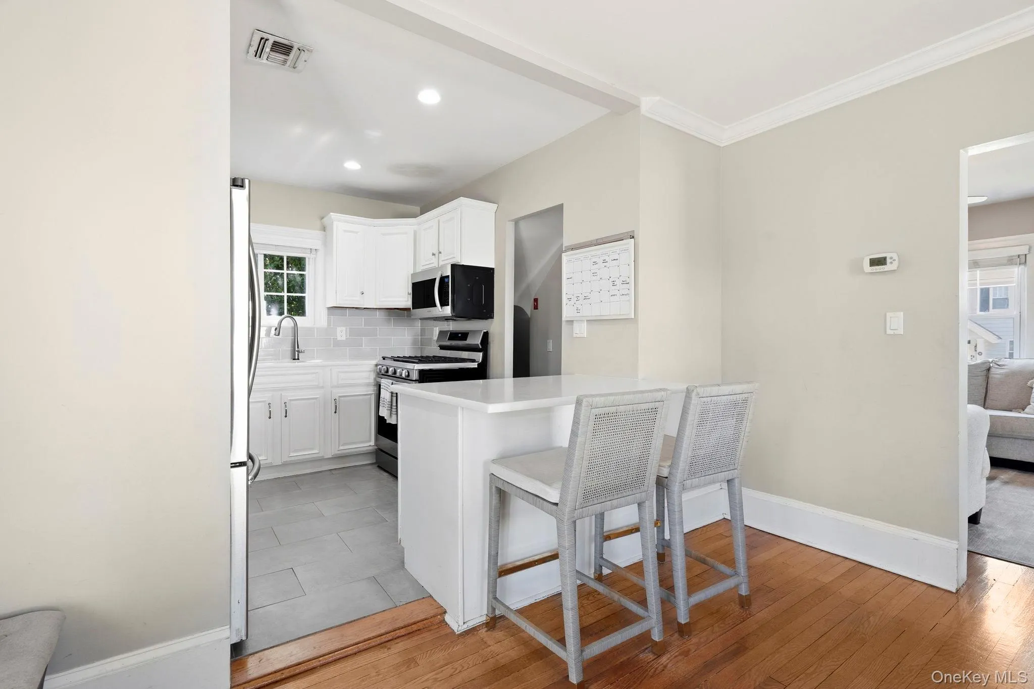 Kitchen featuring white cabinetry, stainless steel appliances, a tile backsplash, and recessed lighting Kitchen featuring white cabinetry, stainless steel appliances, a tile backsplash, and recessed lighting