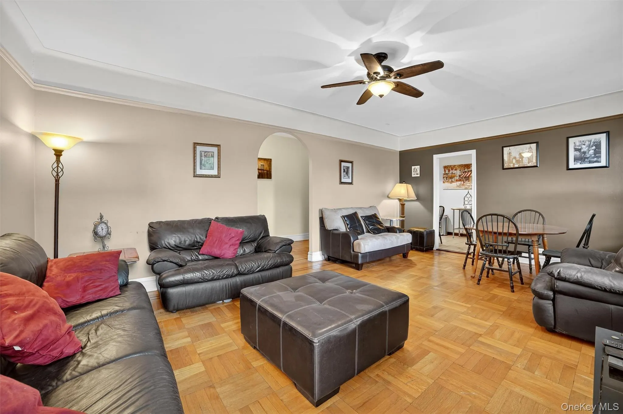 Living area featuring arched walkways and ceiling fan Living area featuring arched walkways and ceiling fan