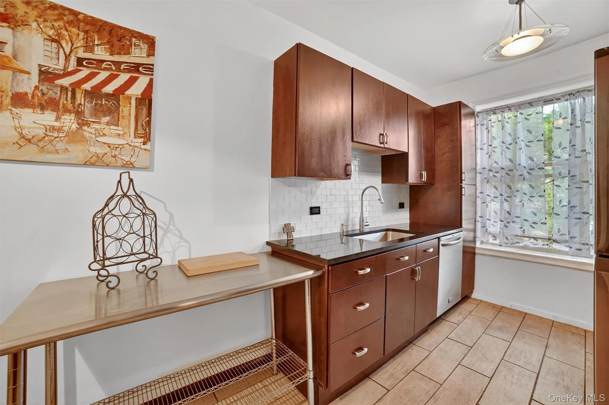 Kitchen with tasteful backsplash, stainless steel dishwasher, and pendant lighting Kitchen with tasteful backsplash, stainless steel dishwasher, and pendant lighting