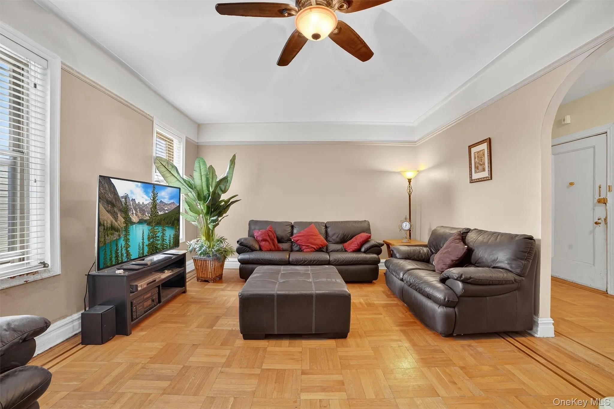Living room featuring arched walkways and a ceiling fan Living room featuring arched walkways and a ceiling fan