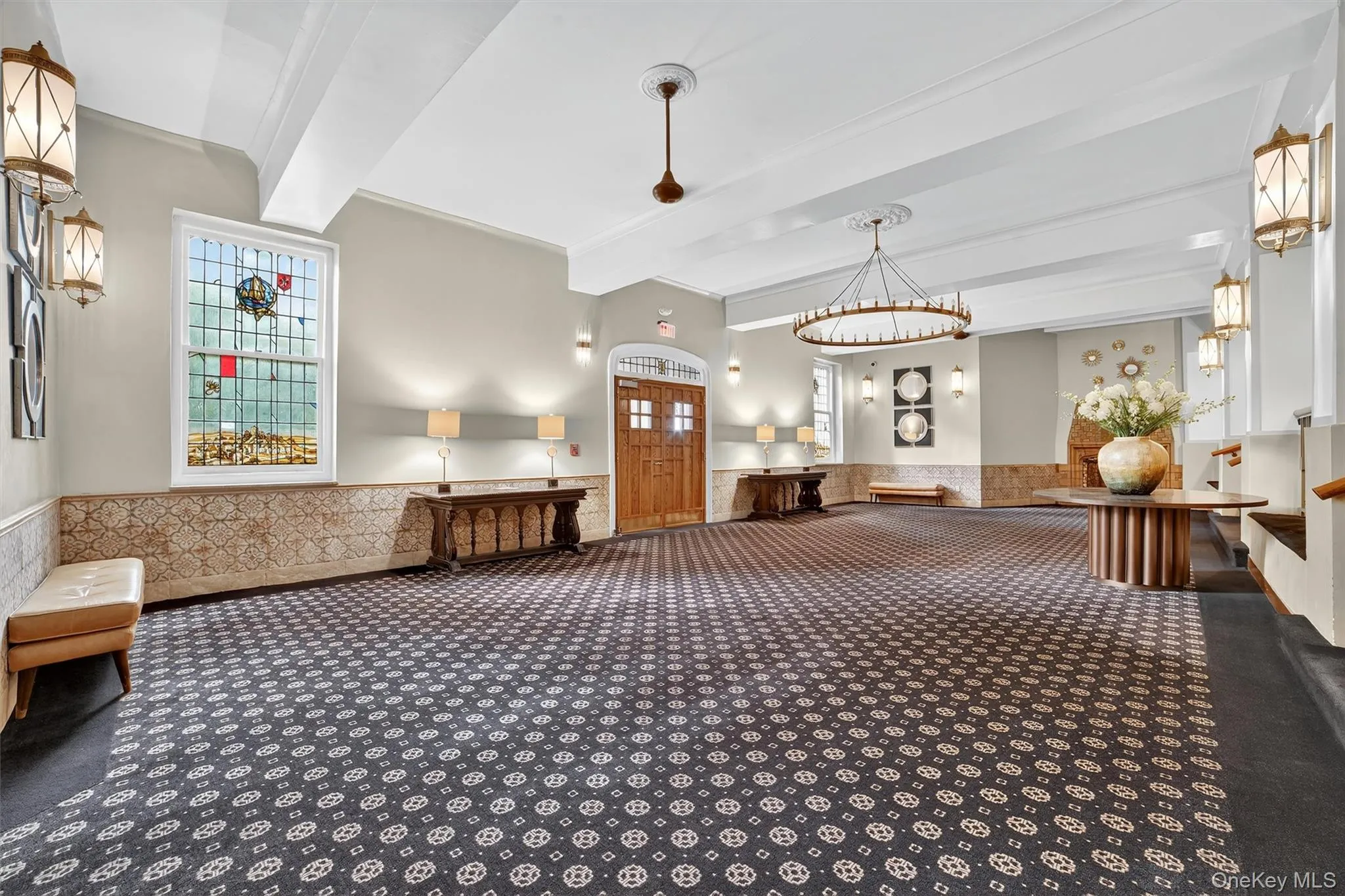 Lobby featuring beam ceiling and a wainscoted wall Lobby featuring beam ceiling and a wainscoted wall
