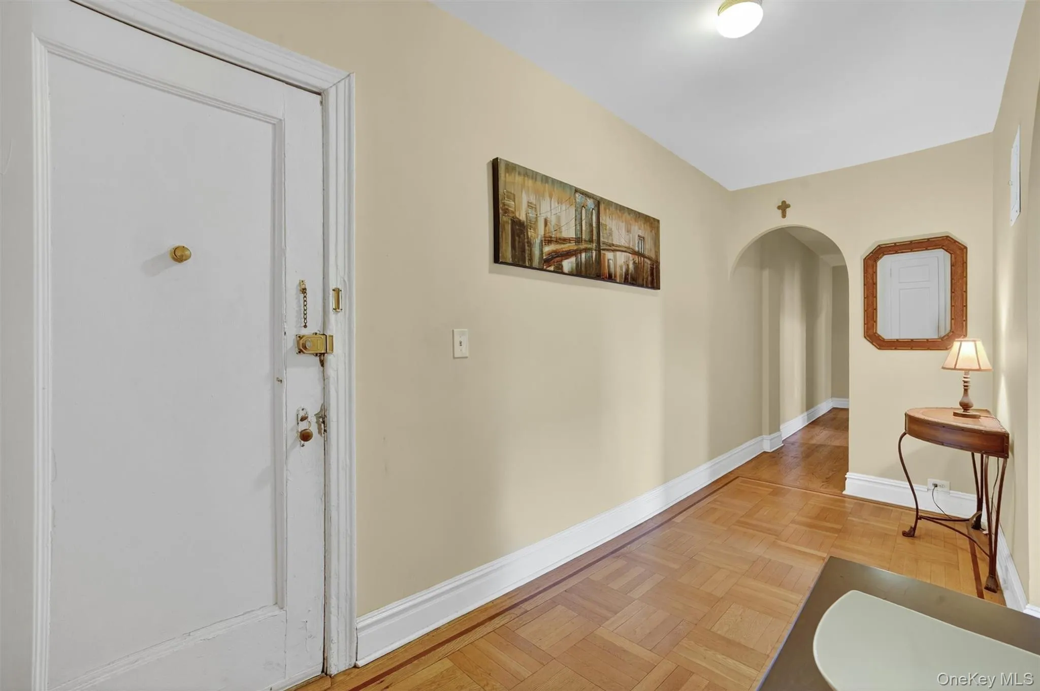 Hall featuring baseboards and arched walkways Hall featuring baseboards and arched walkways