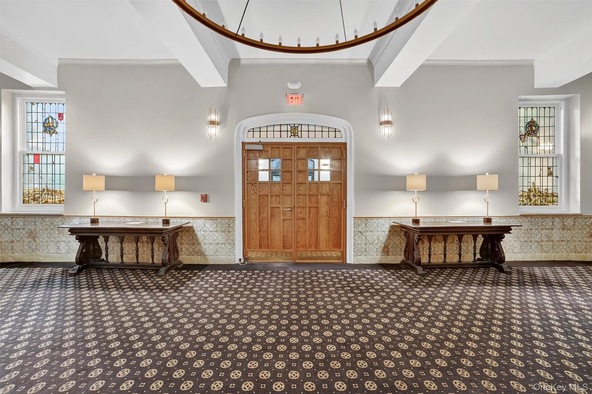 Carpeted entrance foyer featuring beamed ceiling and a wainscoted wall Carpeted entrance foyer featuring beamed ceiling and a wainscoted wall