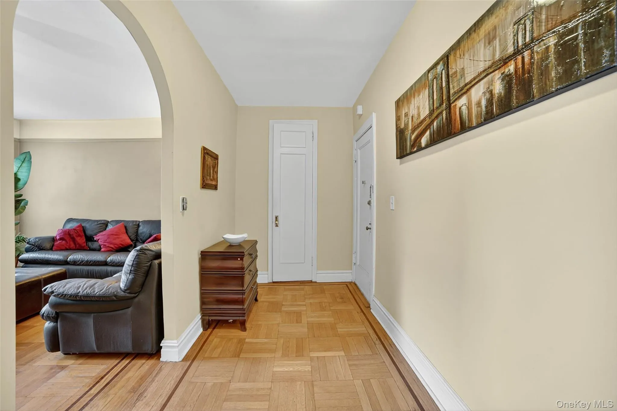 Hallway featuring arched walkways and baseboards Hallway featuring arched walkways and baseboards
