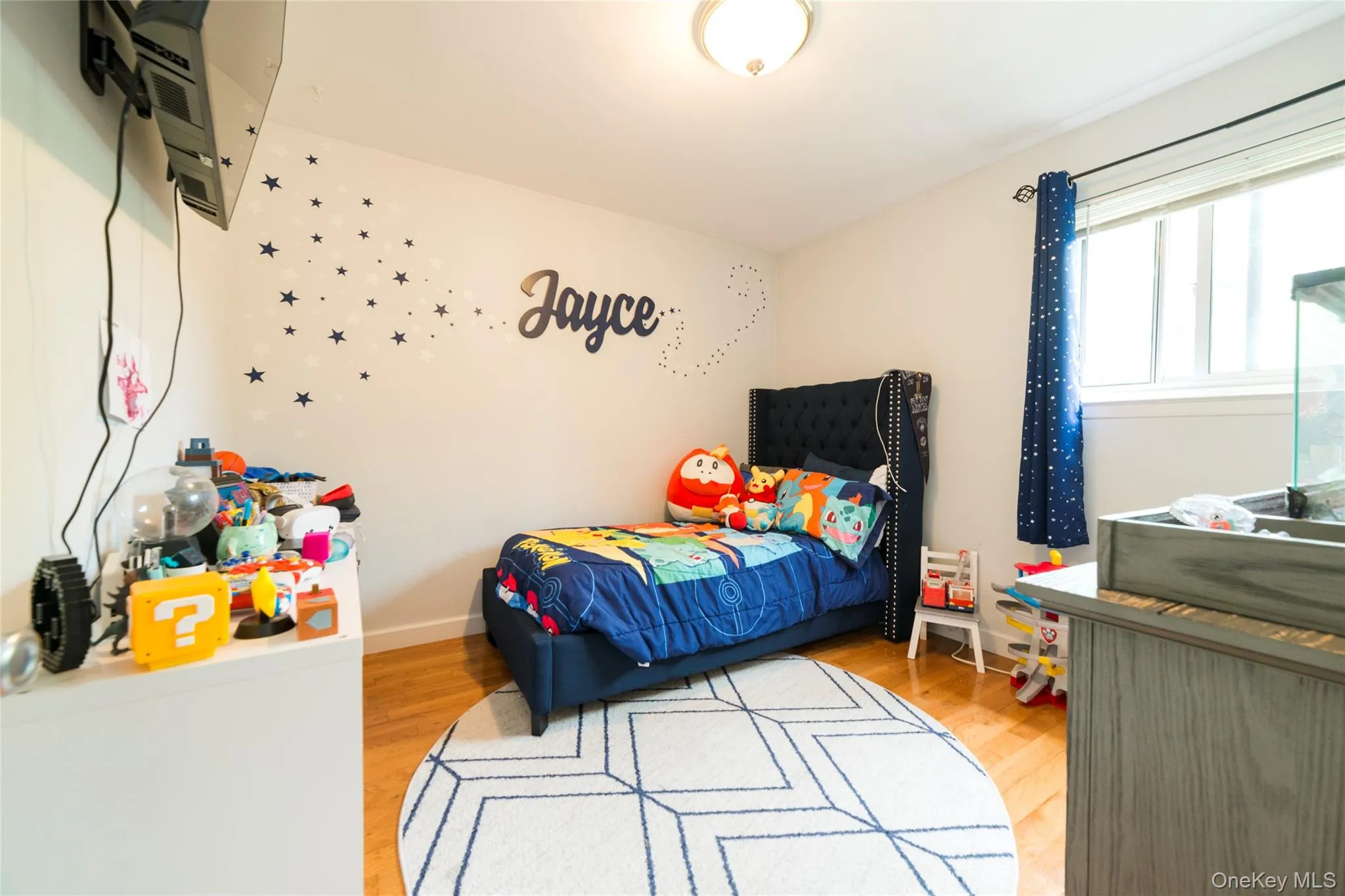 The second bedroom offers wood-finish flooring and a bright window with white trim, filling the space with natural light. The second bedroom offers wood-finish flooring and a bright window with white trim, filling the space with natural light.