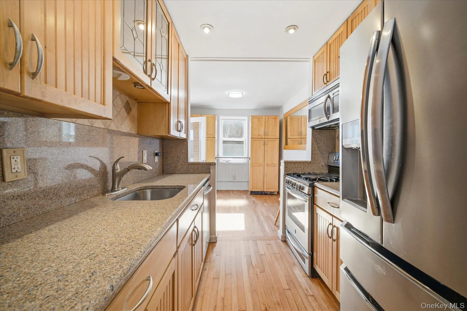 Kitchen with hardwood floors and stainless steel appliances Kitchen with hardwood floors and stainless steel appliances