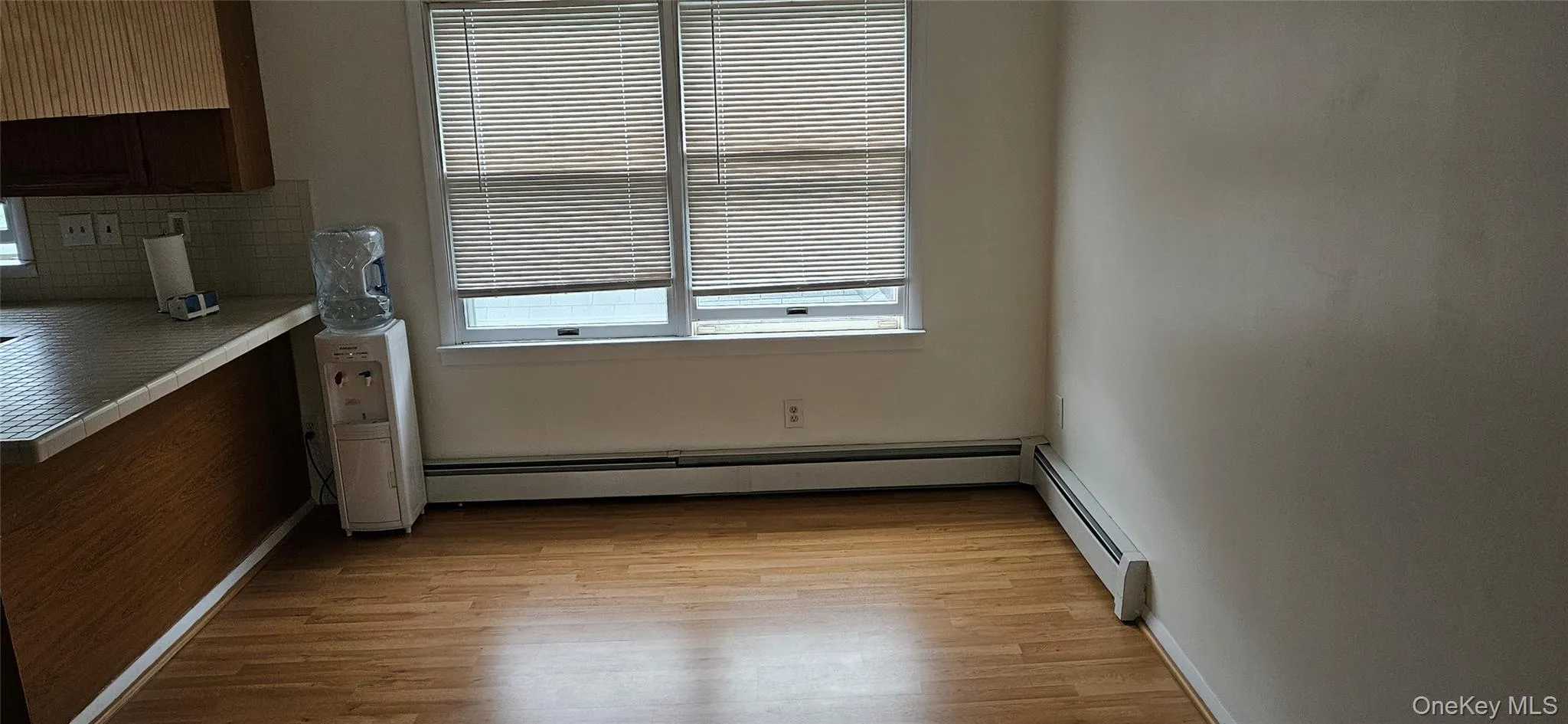 Dining area featuring wood-finish flooring and two windows with blinds Dining area featuring wood-finish flooring and two windows with blinds