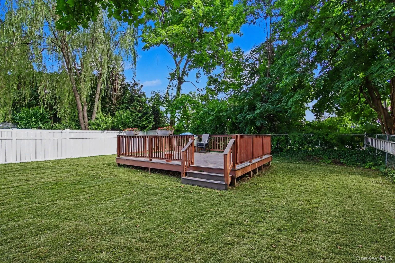 Level, private backyard and wood deck. Level, private backyard and wood deck.