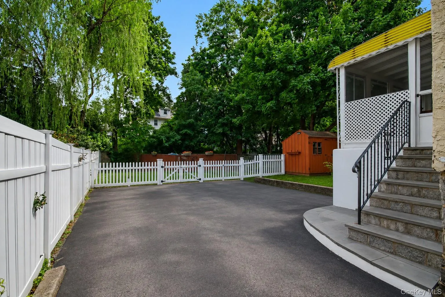 Extra deep paved driveway with steps to porch with door into home. Extra deep paved driveway with steps to porch with door into home.