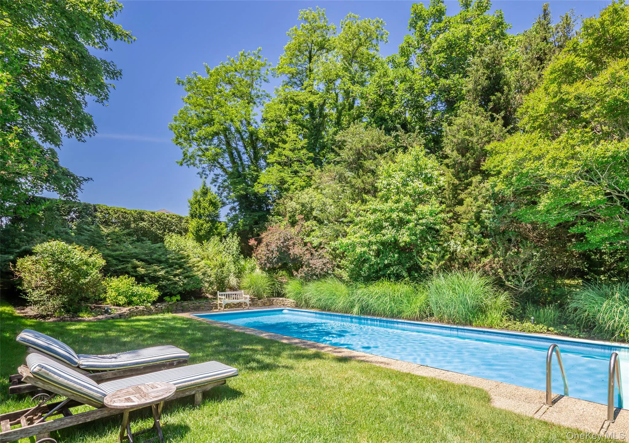 Rectangular in-ground swimming pool with a light blue interior finish and textured concrete coping Rectangular in-ground swimming pool with a light blue interior finish and textured concrete coping