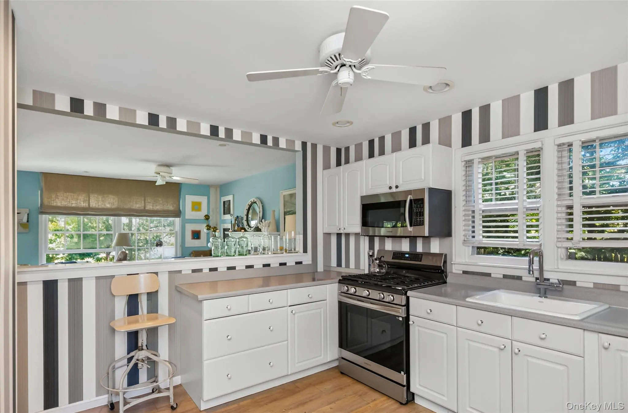 Country kitchen with white cabinetry, stainless steel appliances, and light gray countertops Country kitchen with white cabinetry, stainless steel appliances, and light gray countertops