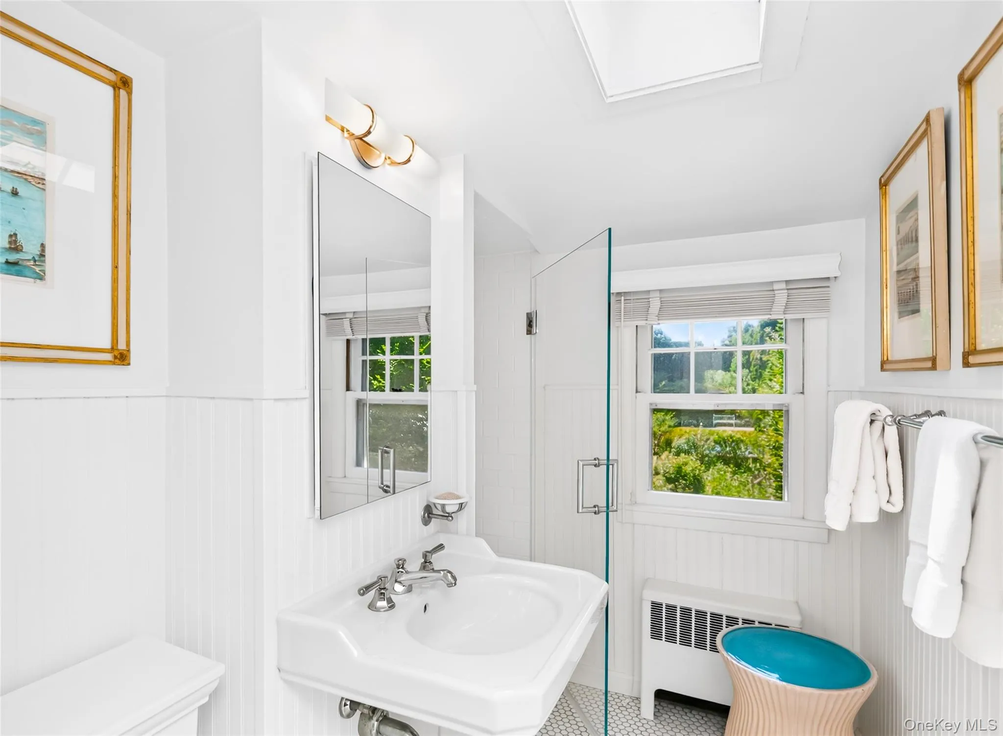 Bathroom featuring wainscoting and a pedestal sink with chrome fixtures Bathroom featuring wainscoting and a pedestal sink with chrome fixtures