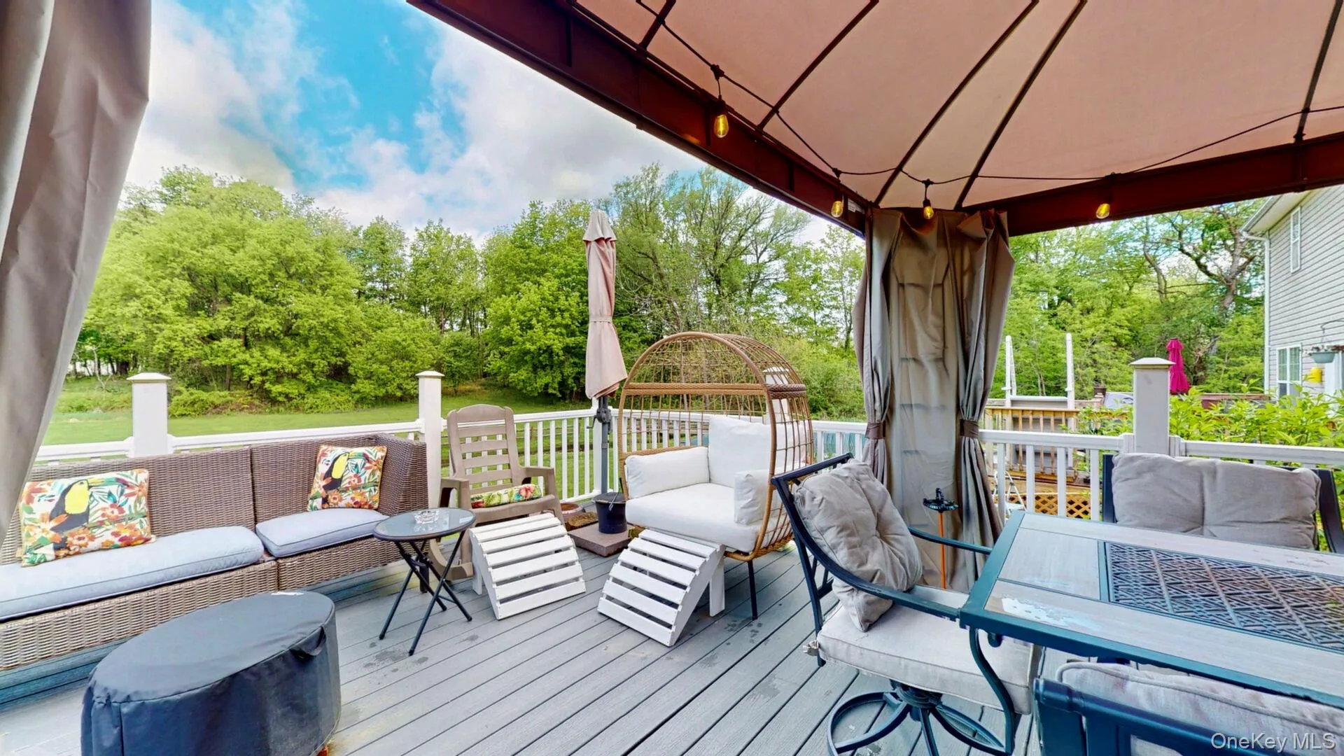 Wooden deck featuring an outdoor living space, view of scattered trees, and a gazebo Wooden deck featuring an outdoor living space, view of scattered trees, and a gazebo