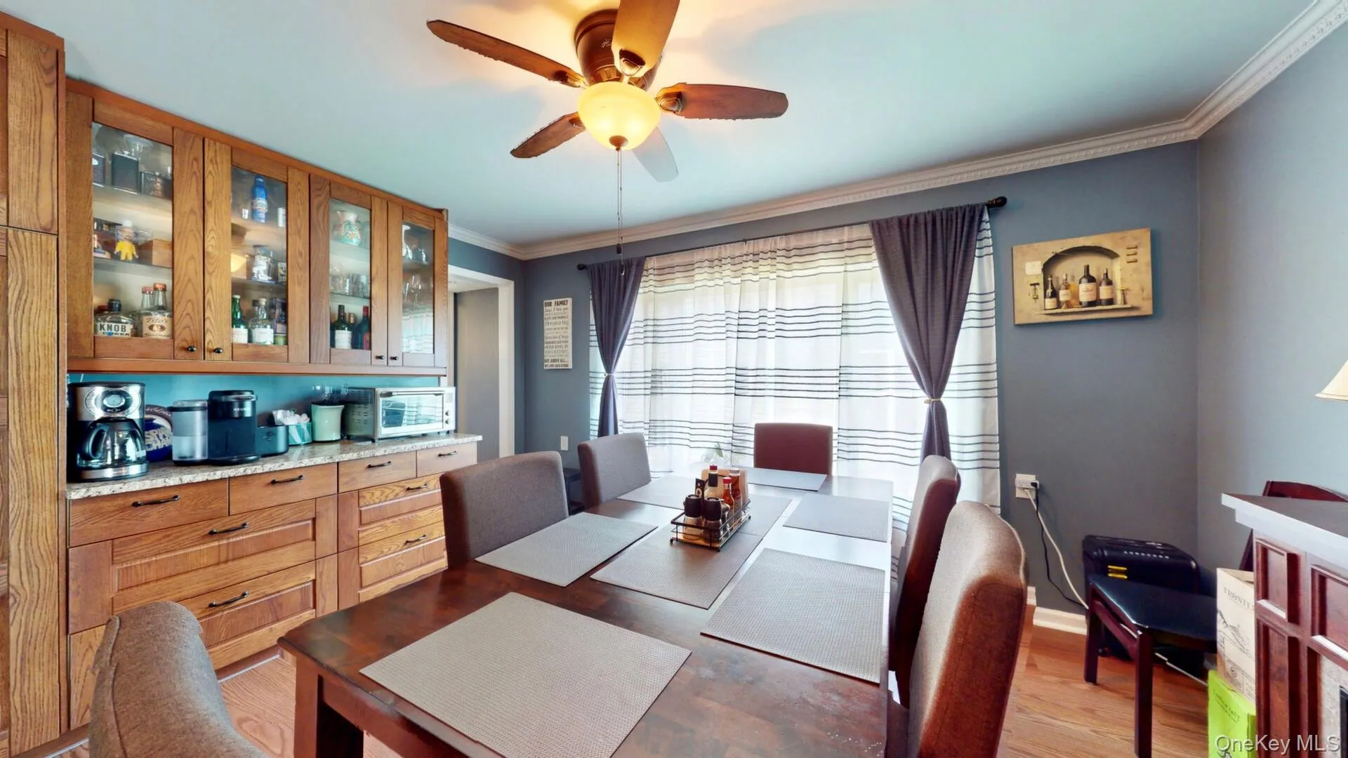 Dining room with ceiling fan, crown molding, and light wood-style flooring Dining room with ceiling fan, crown molding, and light wood-style flooring