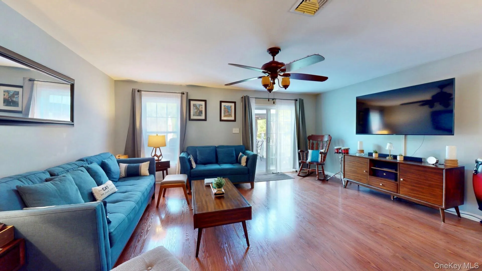 Living room with plenty of natural light, wood finished floors, ceiling fan, and baseboards Living room with plenty of natural light, wood finished floors, ceiling fan, and baseboards