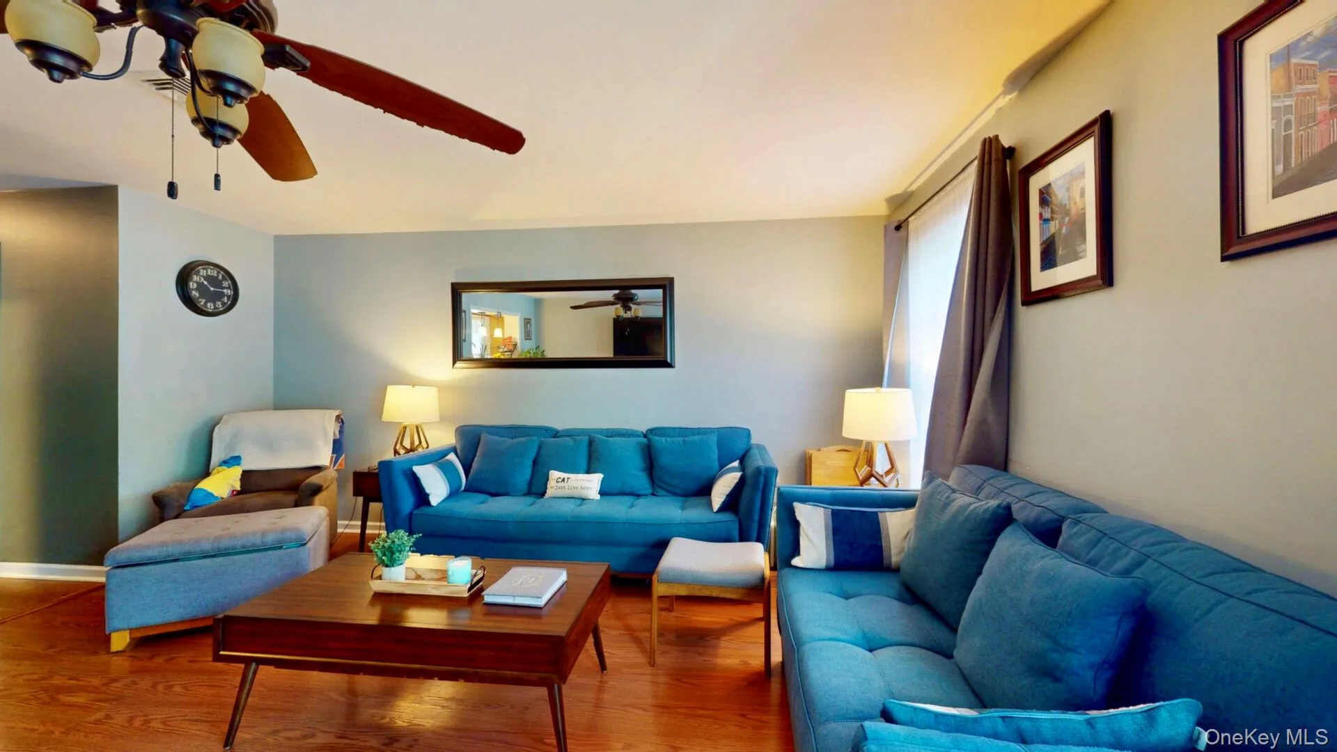 Living area with a ceiling fan, wood finished floors, and baseboards Living area with a ceiling fan, wood finished floors, and baseboards