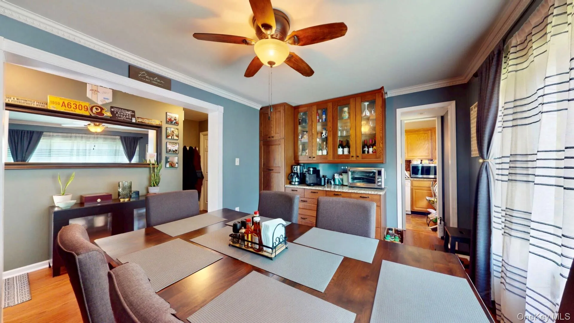 Dining space featuring ceiling fan, light wood-style flooring, crown molding, and baseboards Dining space featuring ceiling fan, light wood-style flooring, crown molding, and baseboards