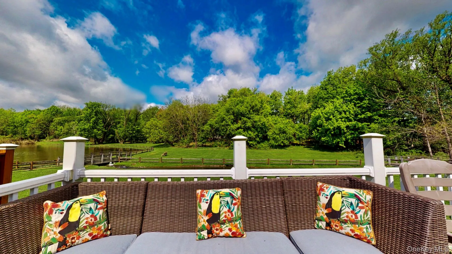 Wooden deck featuring fence, a water view, and a view of trees Wooden deck featuring fence, a water view, and a view of trees