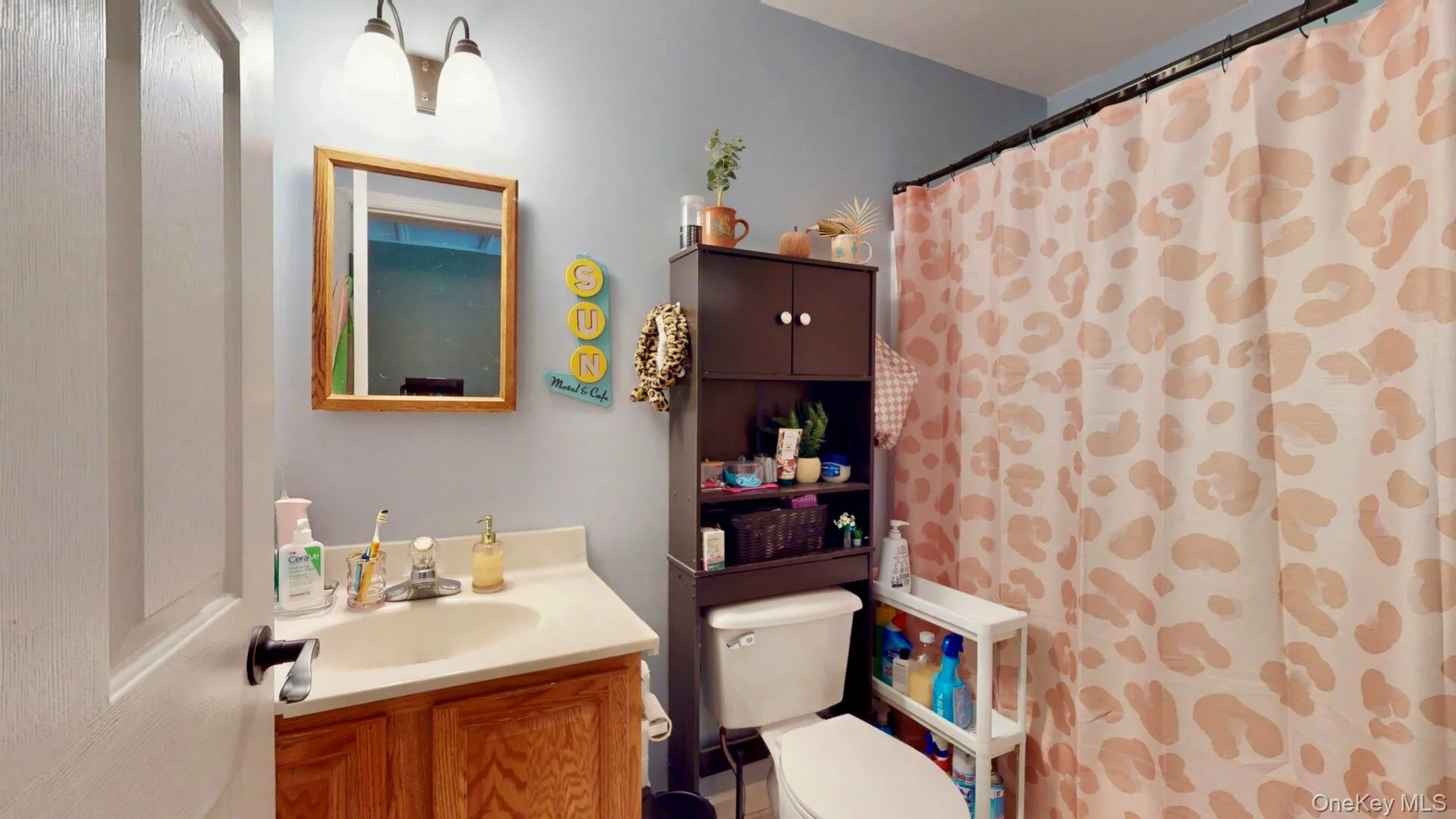 Full bath with toilet, vanity, and curtained shower Full bath with toilet, vanity, and curtained shower