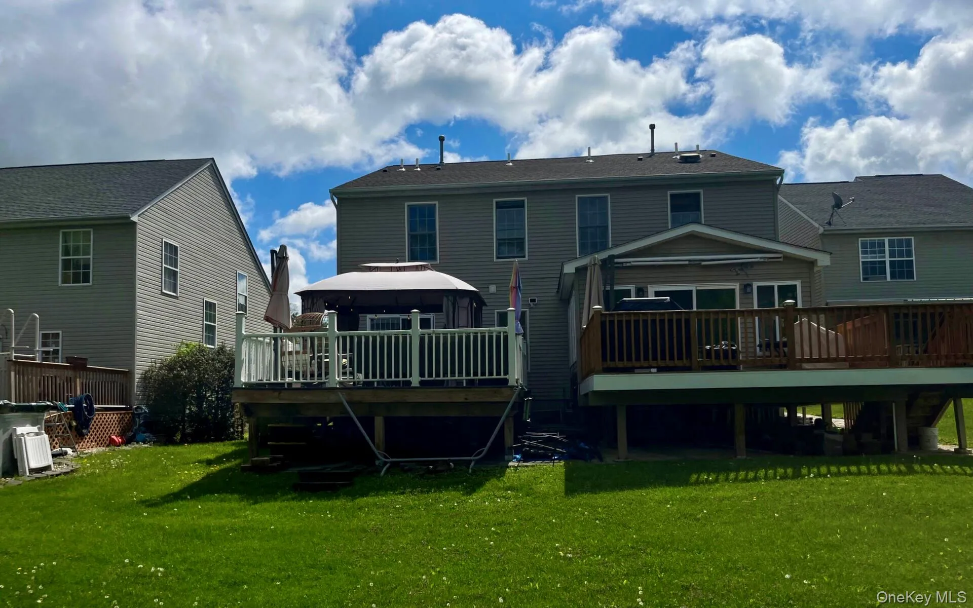 Back of house featuring a deck, a gazebo, and a yard Back of house featuring a deck, a gazebo, and a yard